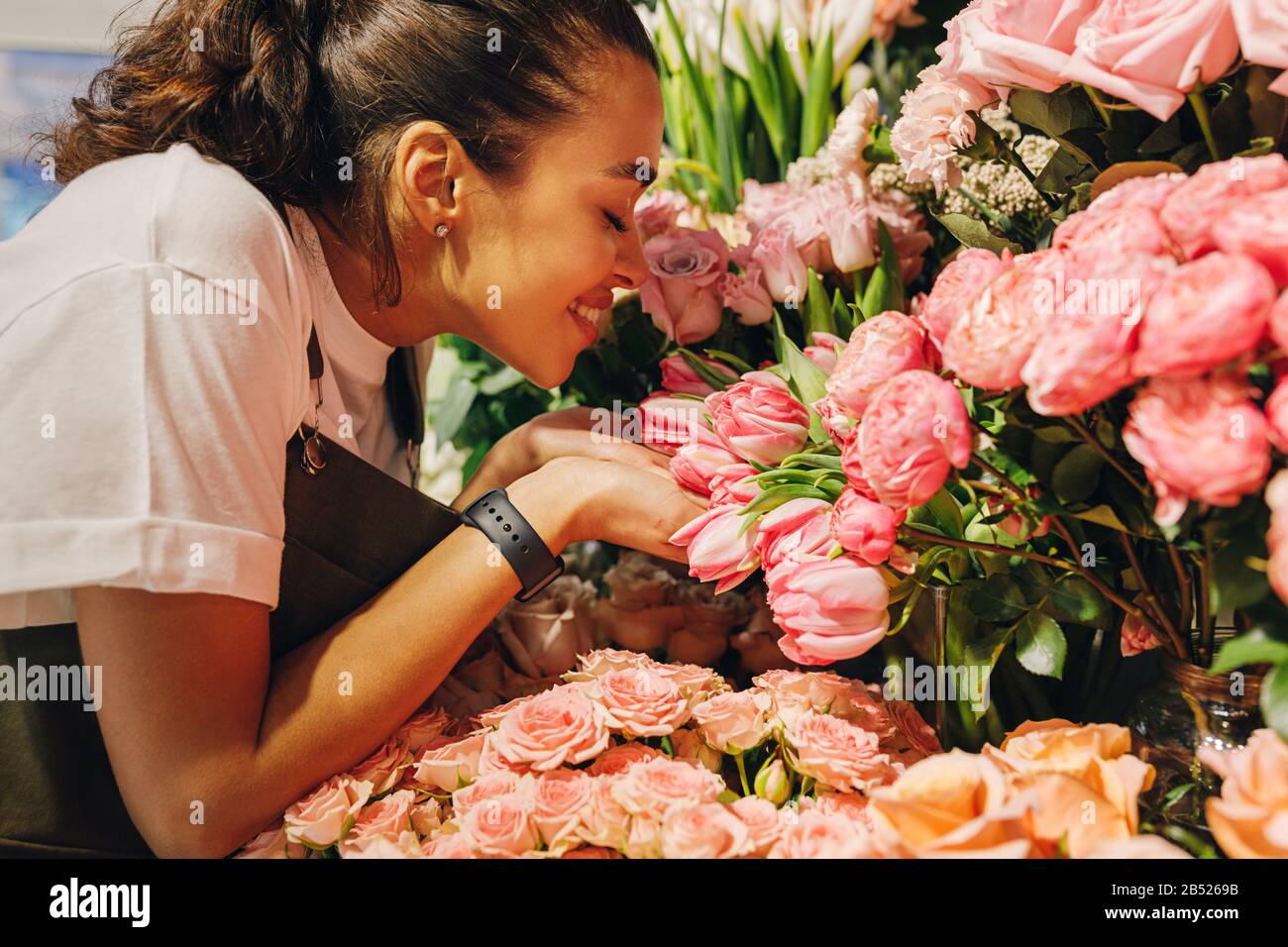 Side view of a young woman smelling the flowers with closed eyes Stock ...