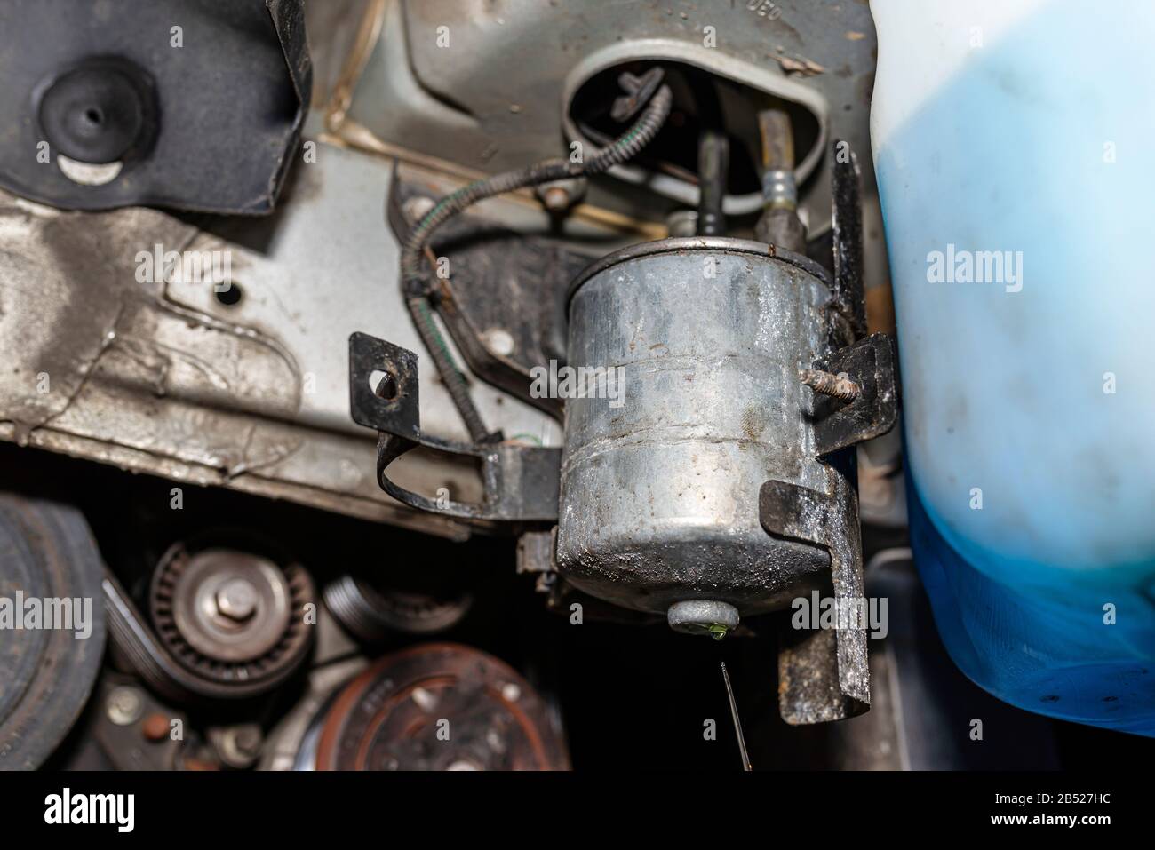Worn fuel filter installed in the car in the wheel arch, visible
