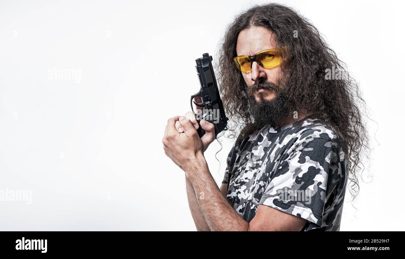 Portrait of the skinny, funny guy holding a gun Stock Photo