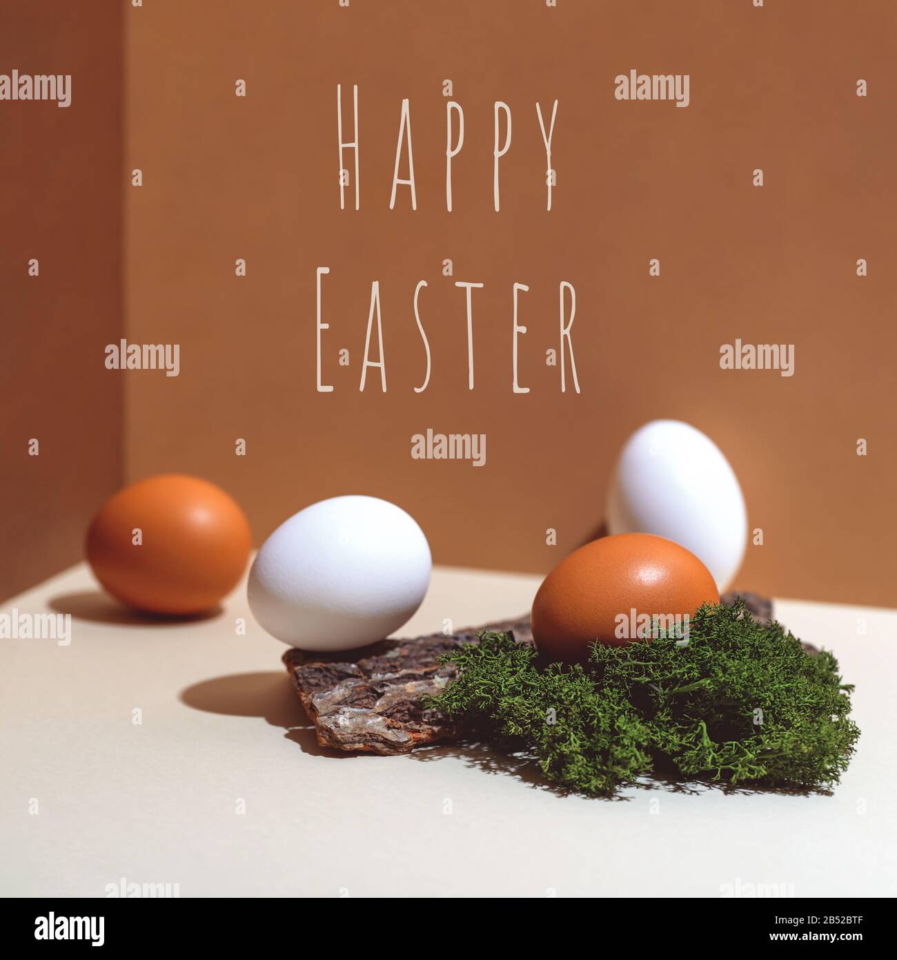 Four multi-colored eggs and natural materials moss and wood. Easter concept. Stock Photo
