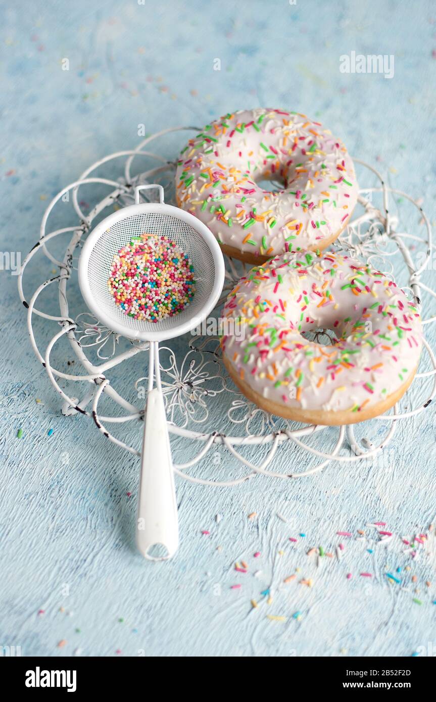 three donuts on a blue background with colorful sugar sprinkles Stock ...