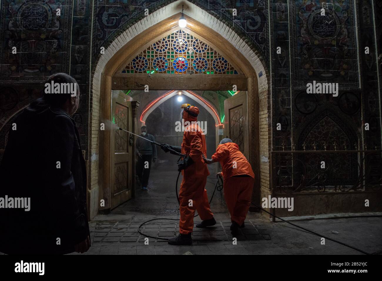 Iranian health ministry staff, the provincial fire department and municipal staffs are disinfecting public places to prevent Coronavirus(COVID19) at late night using machinery and mobile pumps at Historical urban context and alleys of Shiraz city, Fars province, Iran. Schools, Sport cpmplex, Concerts and all social gatherings have been canceled in Iran. Stock Photo