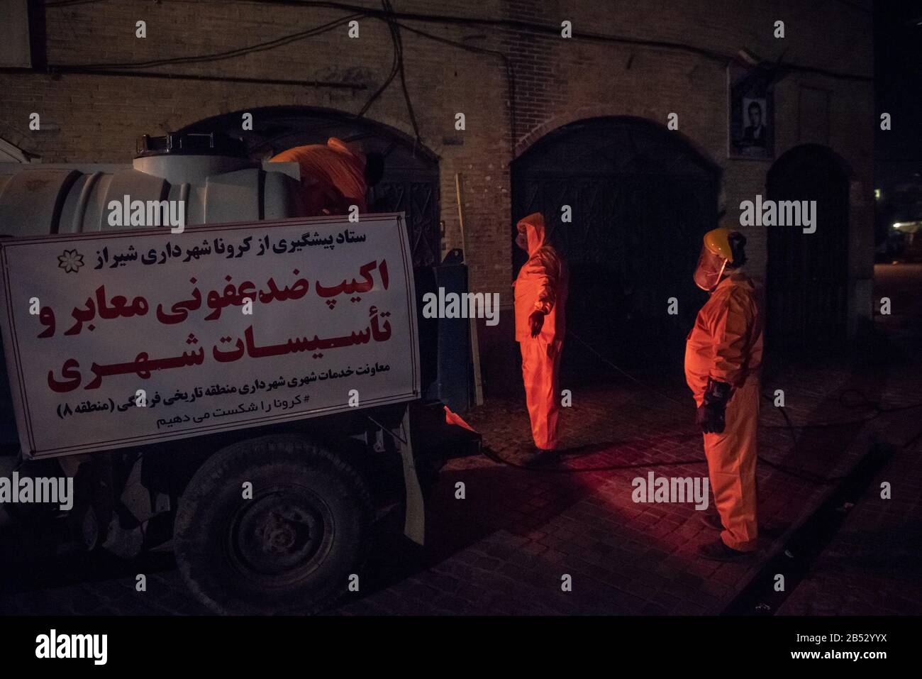 Iranian health ministry staff, the provincial fire department and municipal staffs are disinfecting public places to prevent Coronavirus(COVID19) at late night using machinery and mobile pumps at Historical urban context and alleys of Shiraz city, Fars province, Iran. Schools, Sport cpmplex, Concerts and all social gatherings have been canceled in Iran. Stock Photo