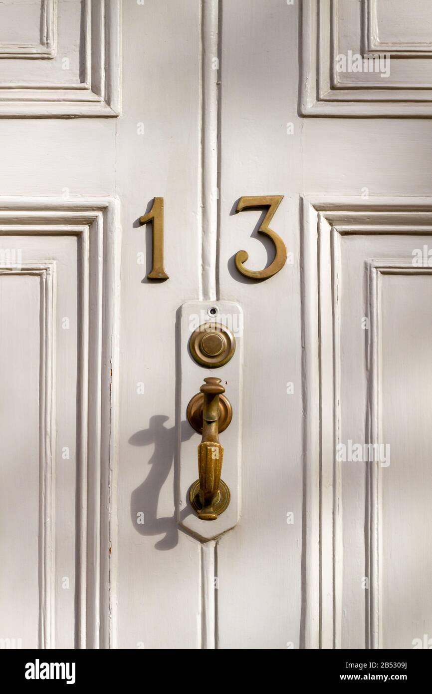 Elegant white wooden front door with the house number 13 Stock Photo
