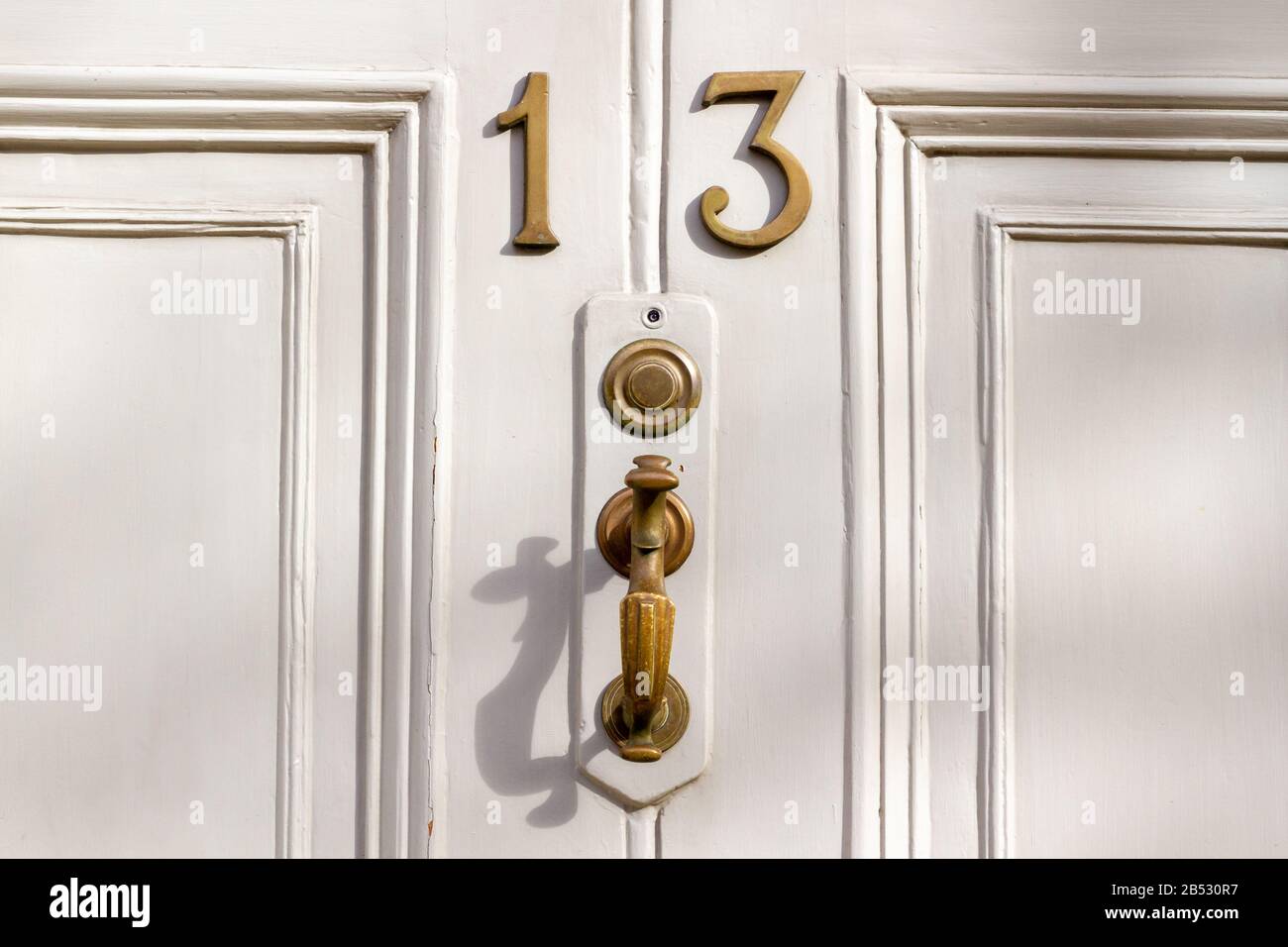 Elegant white wooden front door with the house number 13 Stock Photo