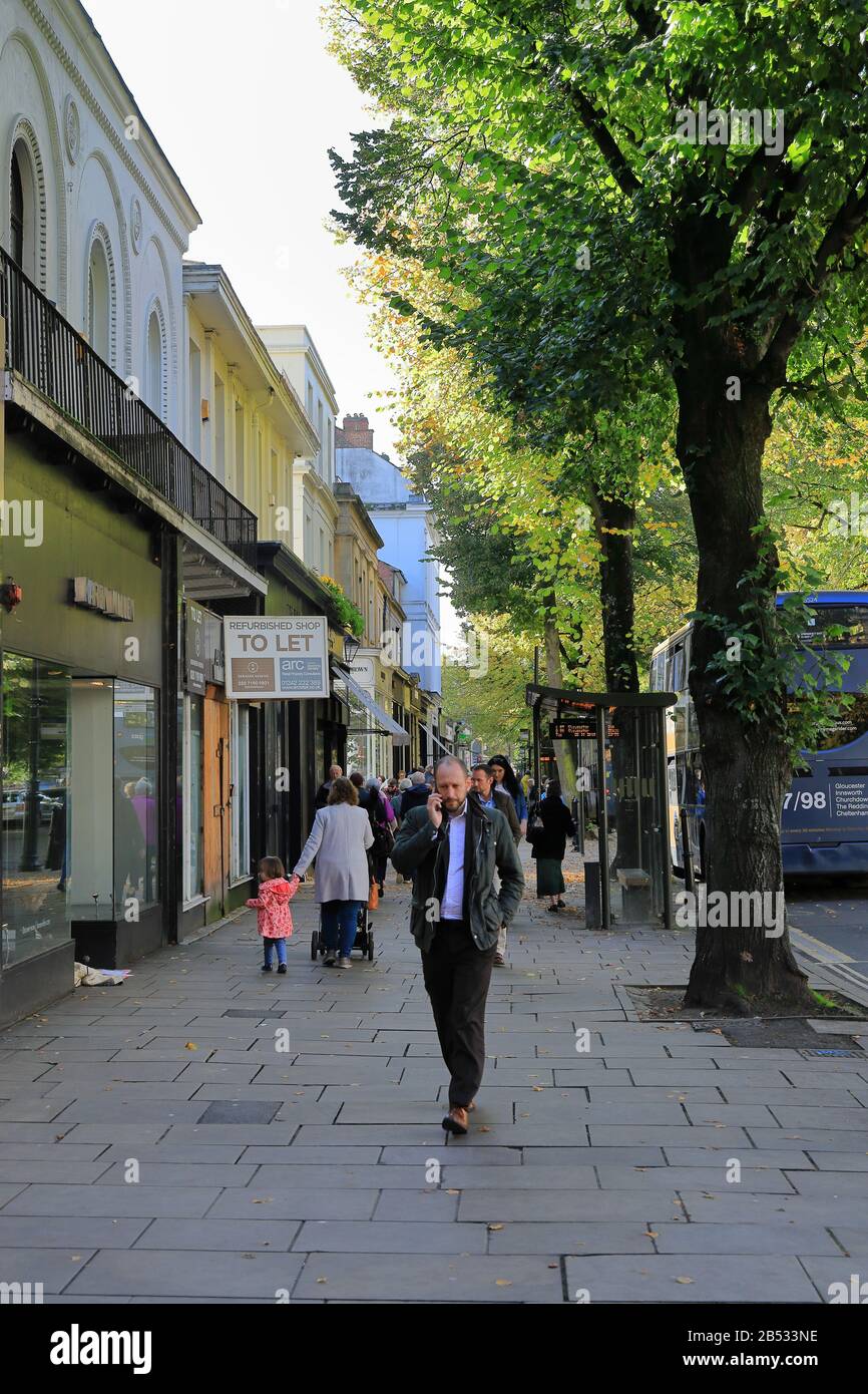 The demise of the High Street. Shops closed with boarded windows and To Let signs, a homeless man in a doorway with a little girl looking. Stock Photo