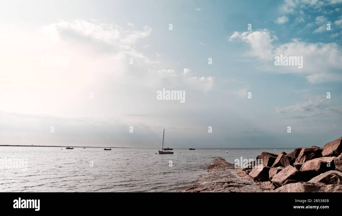 Boats anchored at sunset in front of a beach Stock Photo - Alamy