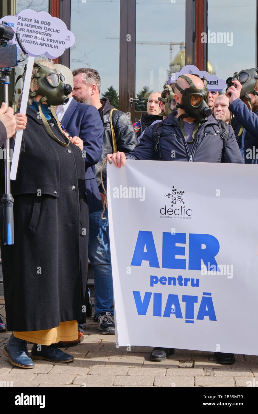 Bucharest, Romania - March 4, 2020: People with gas masks hold a banner saying Air For Life, in protest for extreme air pollution, in Bucharest, Roman Stock Photo