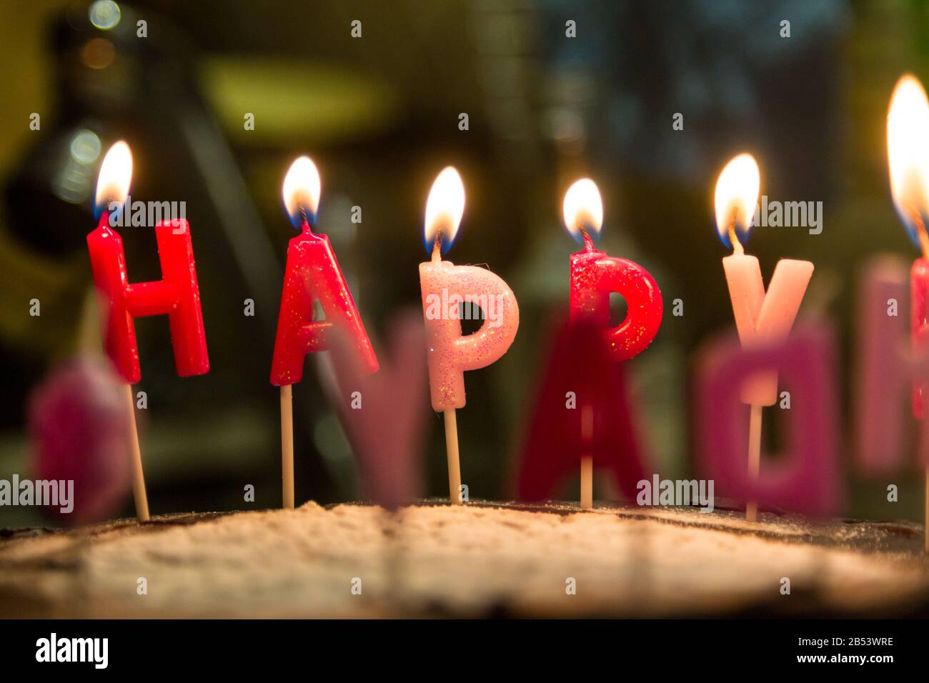 Burning happy birthday letter candles on cake close-up Stock Photo - Alamy