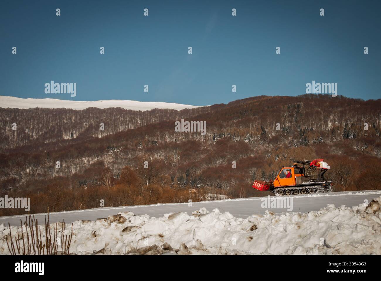 A snowplow clearing a road in the Bieszczady mountains. Winter in Poland Stock Photo