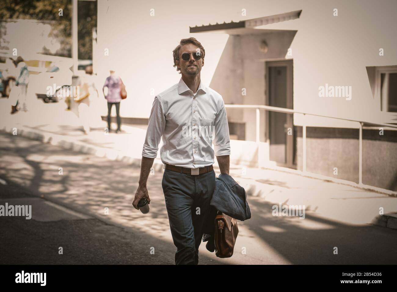 Colored photo of a handsome freelancer walking on the street in a sute Stock Photo