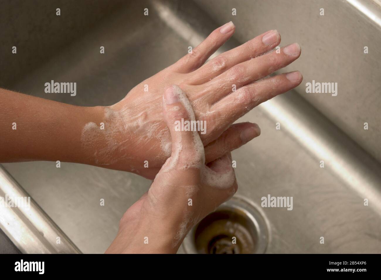 Person washes hands to prevent viral infection and spread of COVID-19 Coronavirus. Stock Photo