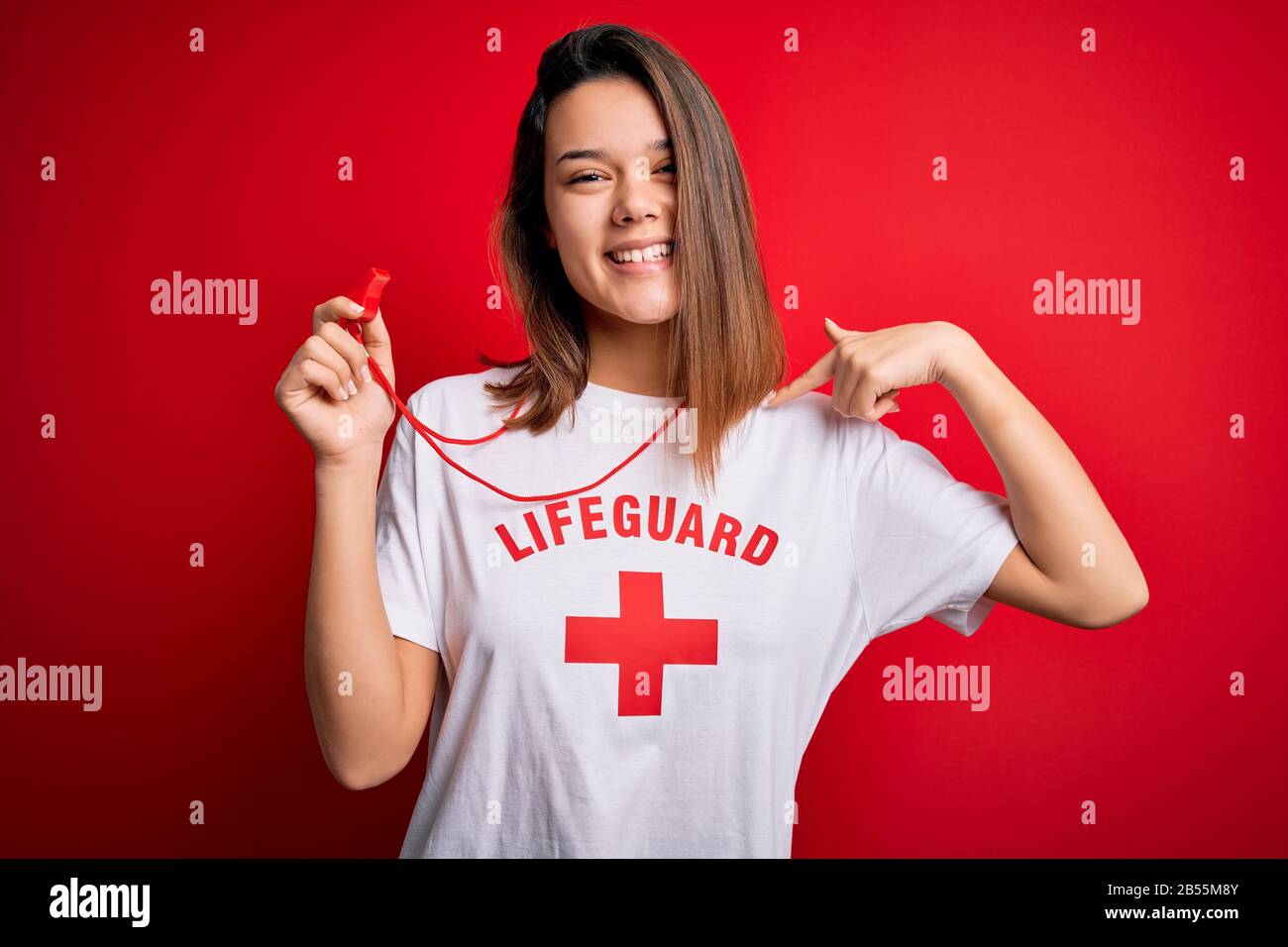 Young beautiful brunette lifeguard girl wearing t-shirt with red cross ...