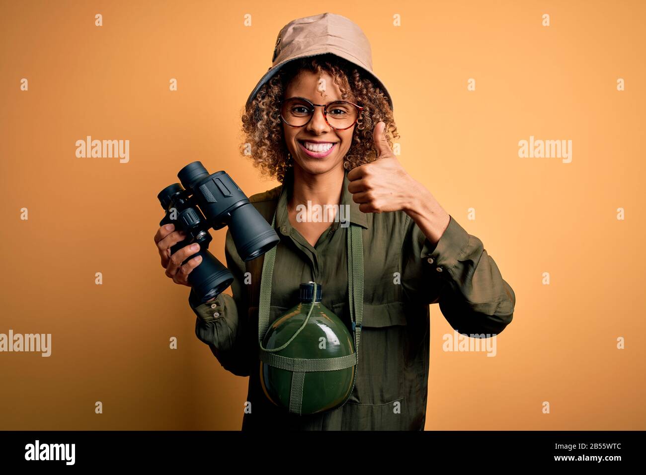 African american tourist woman wearing explorer hat and water canteen ...
