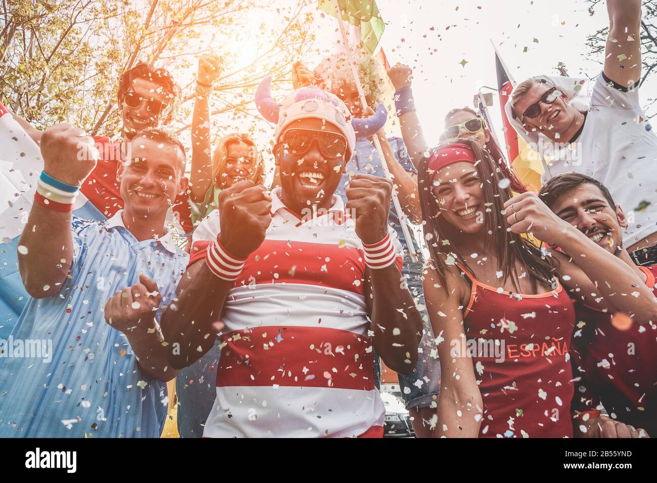 Multinational football supporters celebrating the begin of world competition - Happy multiracial people having fun together outside of stadium - Main Stock Photo