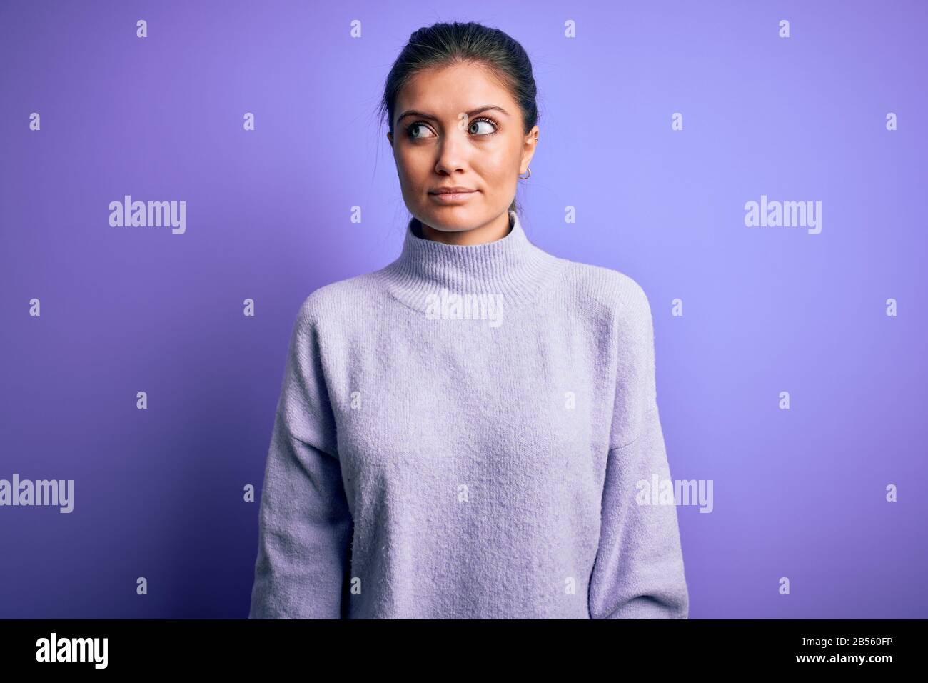 Young beautiful woman with blue eyes wearing casual turtleneck sweater ...