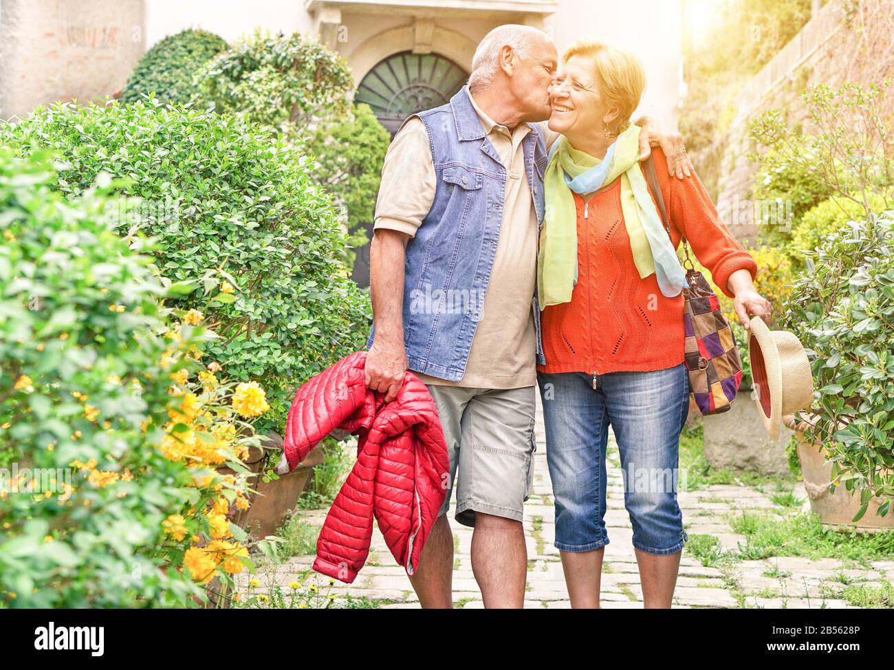 Happy playful senior couple in love tenderly enjoying romantic vacation for wedding anniversary celebration - Joyful elderly active lifestyle - Warm f Stock Photo