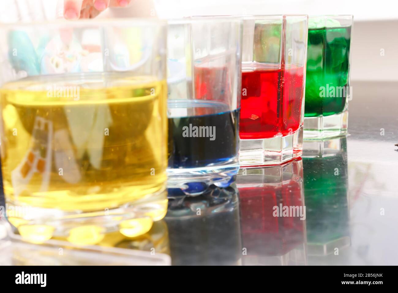 glasses with multicolored coloring water, close-up. Easter preparations. Stock Photo