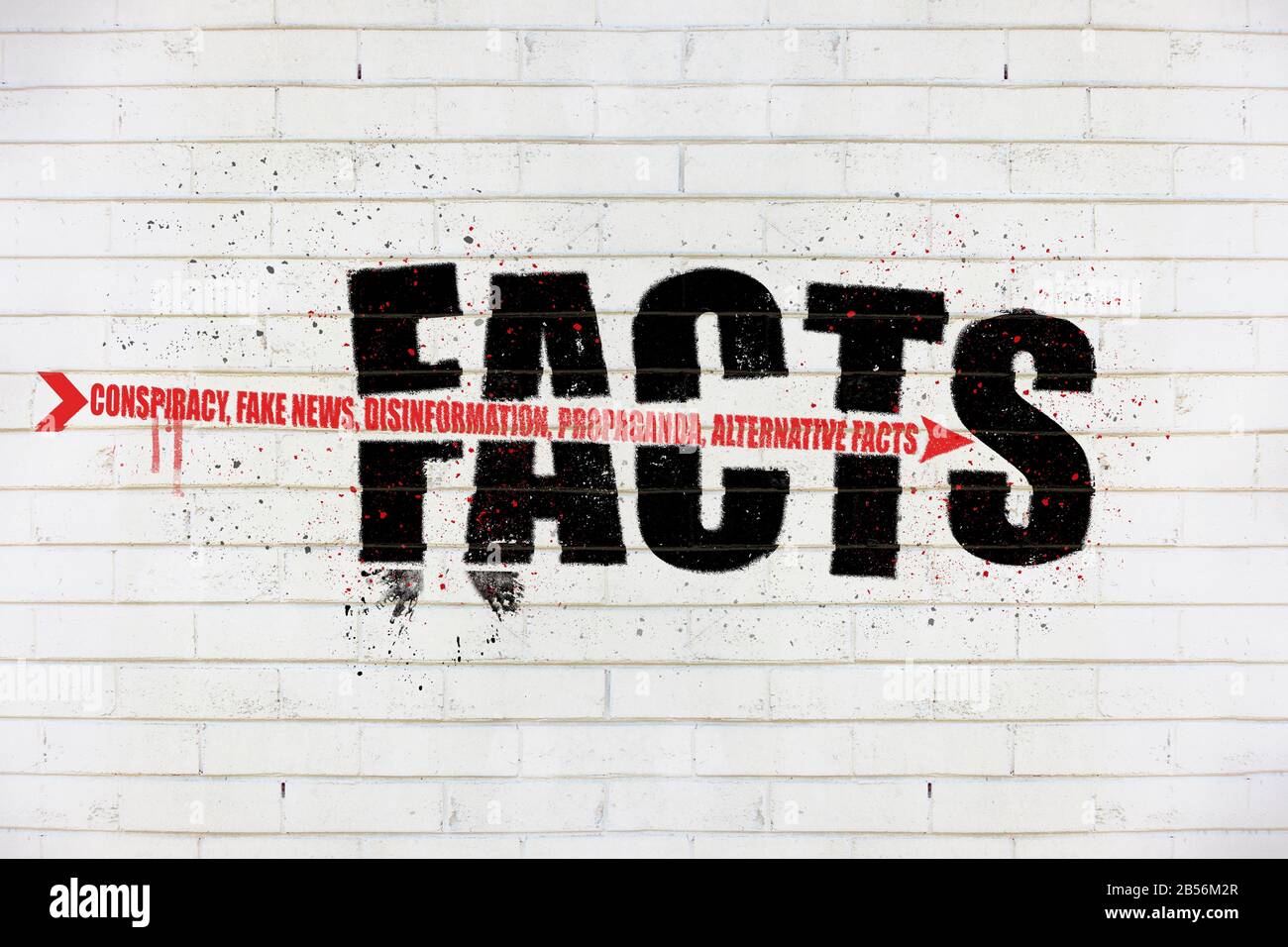 The word Facts with an arrow of conspiracy, fake news, disinformation, propaganda, alternative facts, painted on old white wall, facts being destroyed Stock Photo