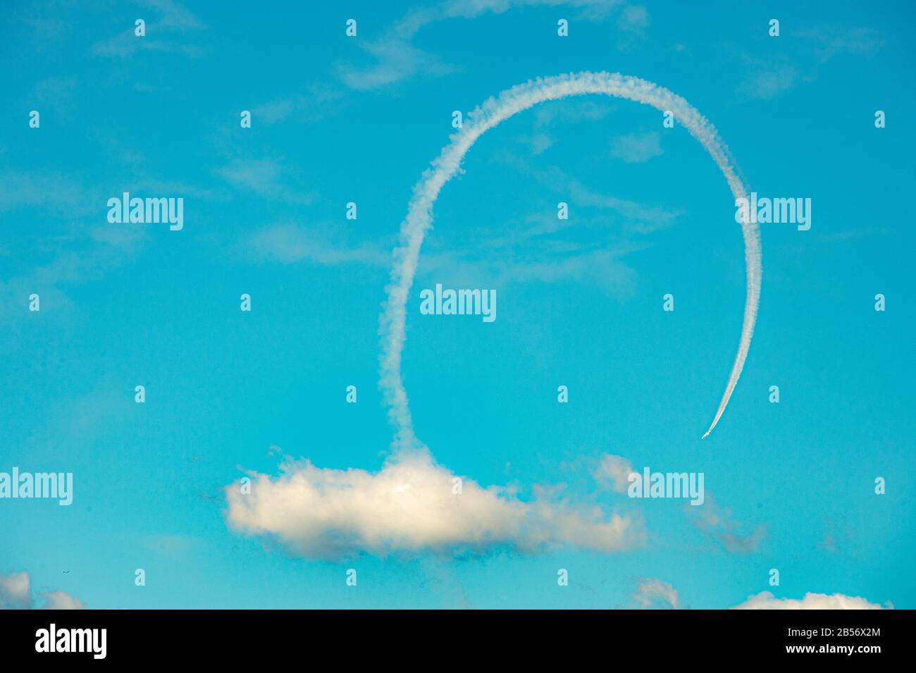 Jet looping through clouds at Air Show Stock Photo