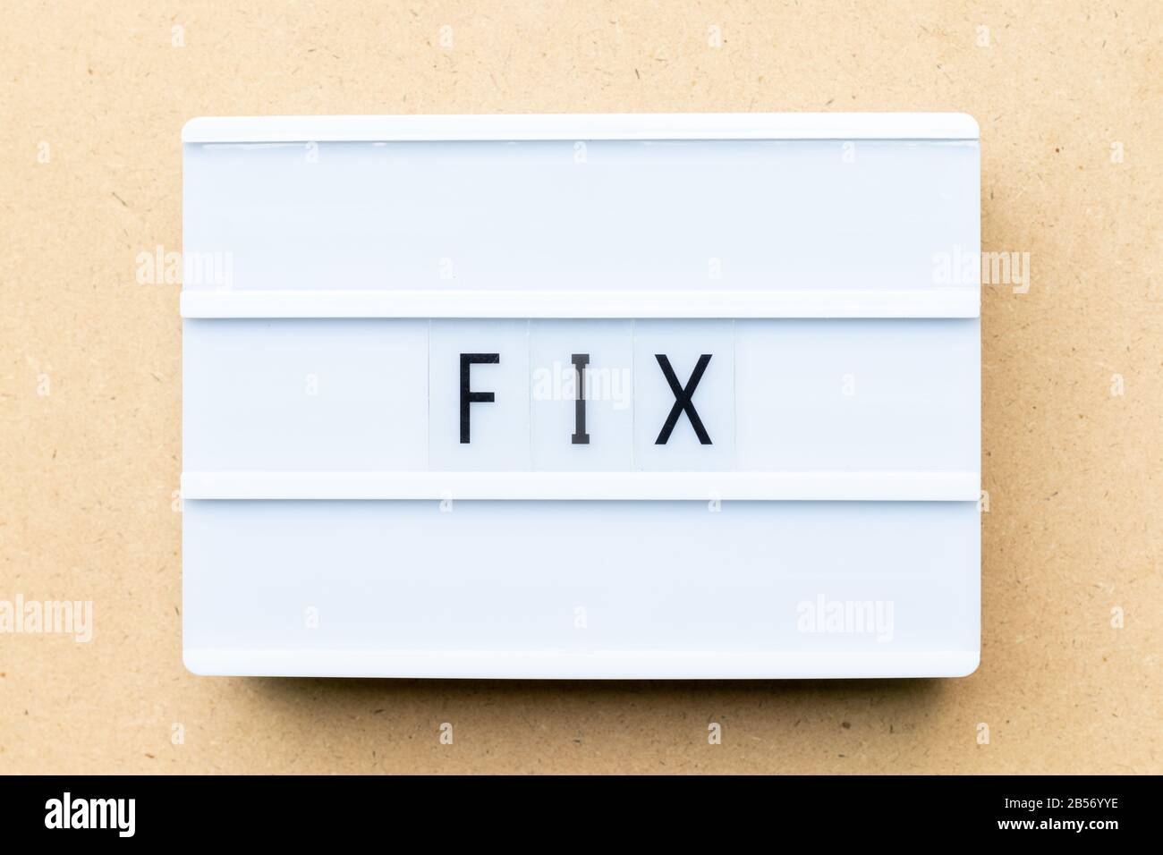 White lightbox with word fix on wood background Stock Photo