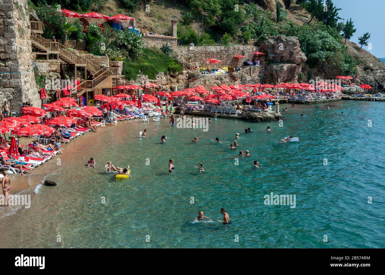 People enjoy bathing at Mermerli Plaji adjacent to the ancient Roman Harbour walls at Kaleici on Antalya  Bay in Turkey on a hot summers day. Stock Photo