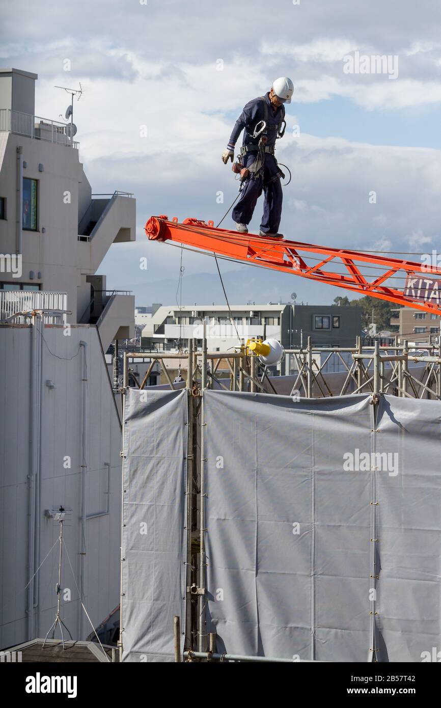 Construction workers set up a crane on a building site in Chuo Rinkan, Kanagawa Japan. Stock Photo