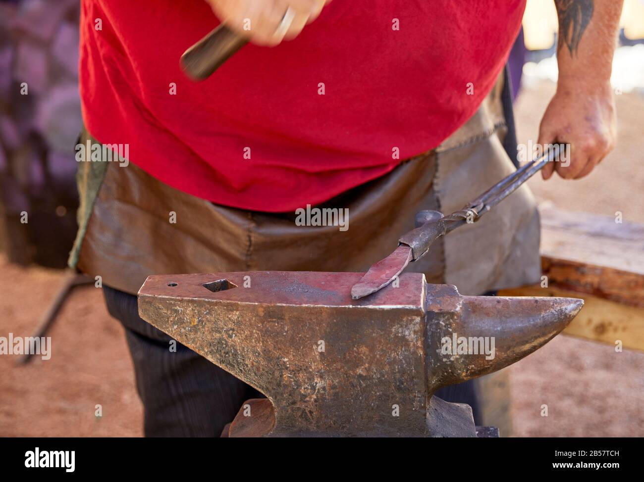 Blacksmith making a steel knife using an anvil and hammer Stock Photo