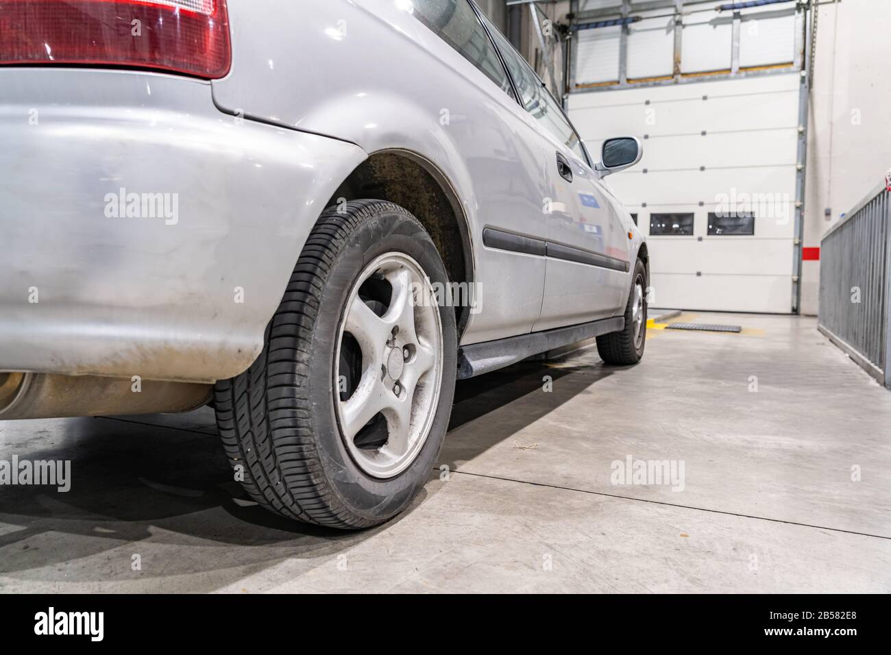 An old car moving forward to be inspected at a vehicle inspection