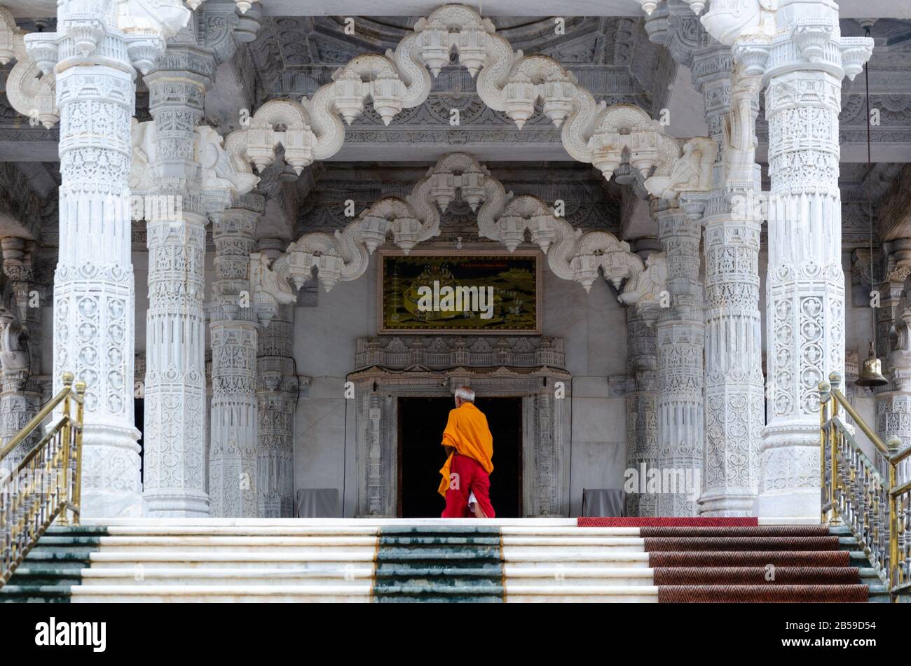 Jain temple priest walking into the entrance of the central temple dedicated to Lord Mahavira from the 72 Jinalaya Jain Temple, Mandvi, Kutch, Gujarat Stock Photo