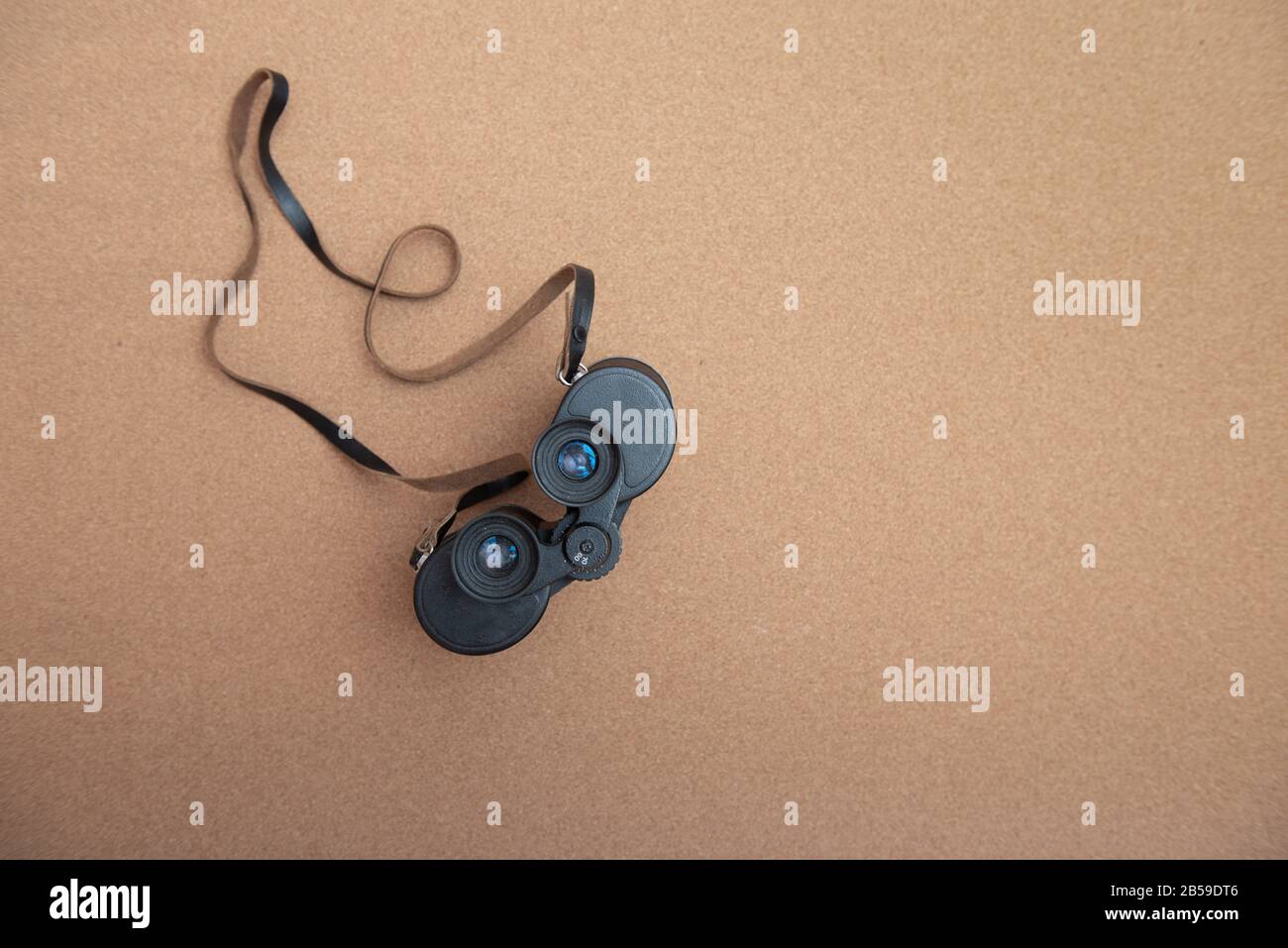 Binoculars on brown background with copy space Stock Photo