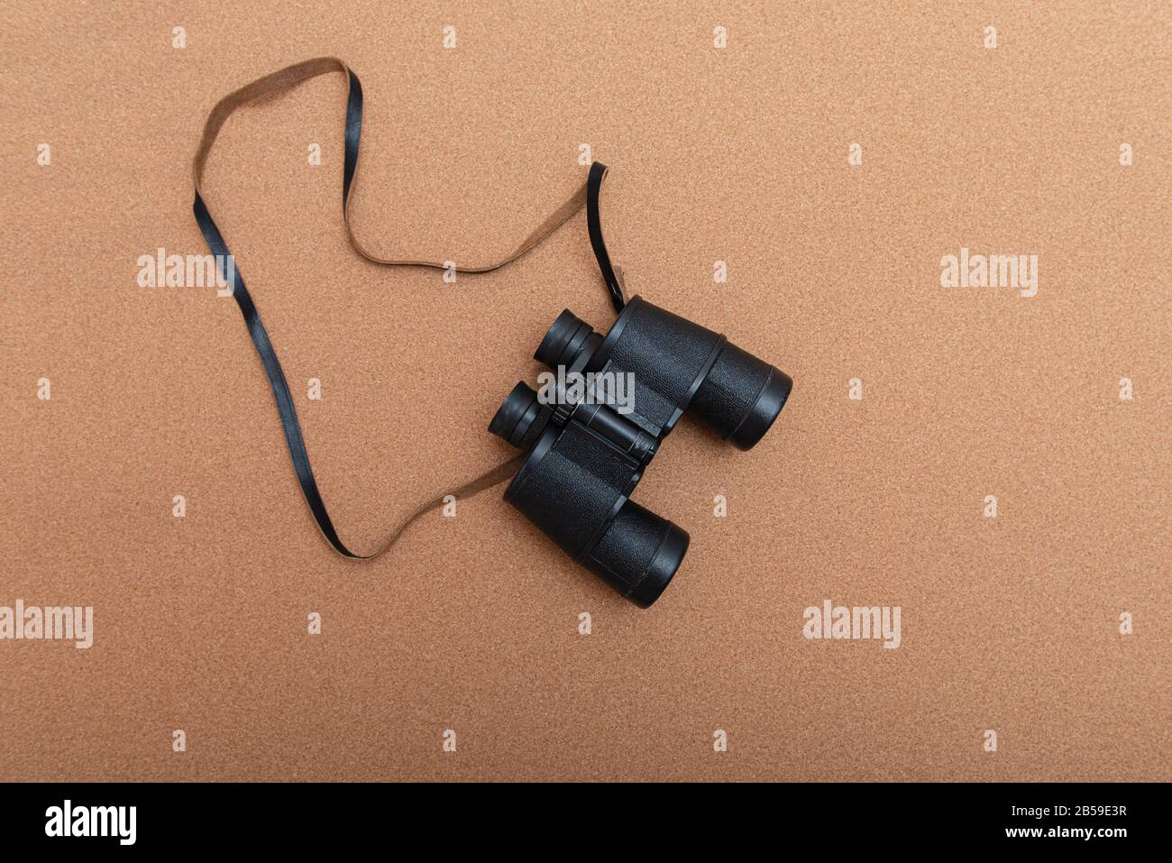 Binoculars on brown background with copy space Stock Photo