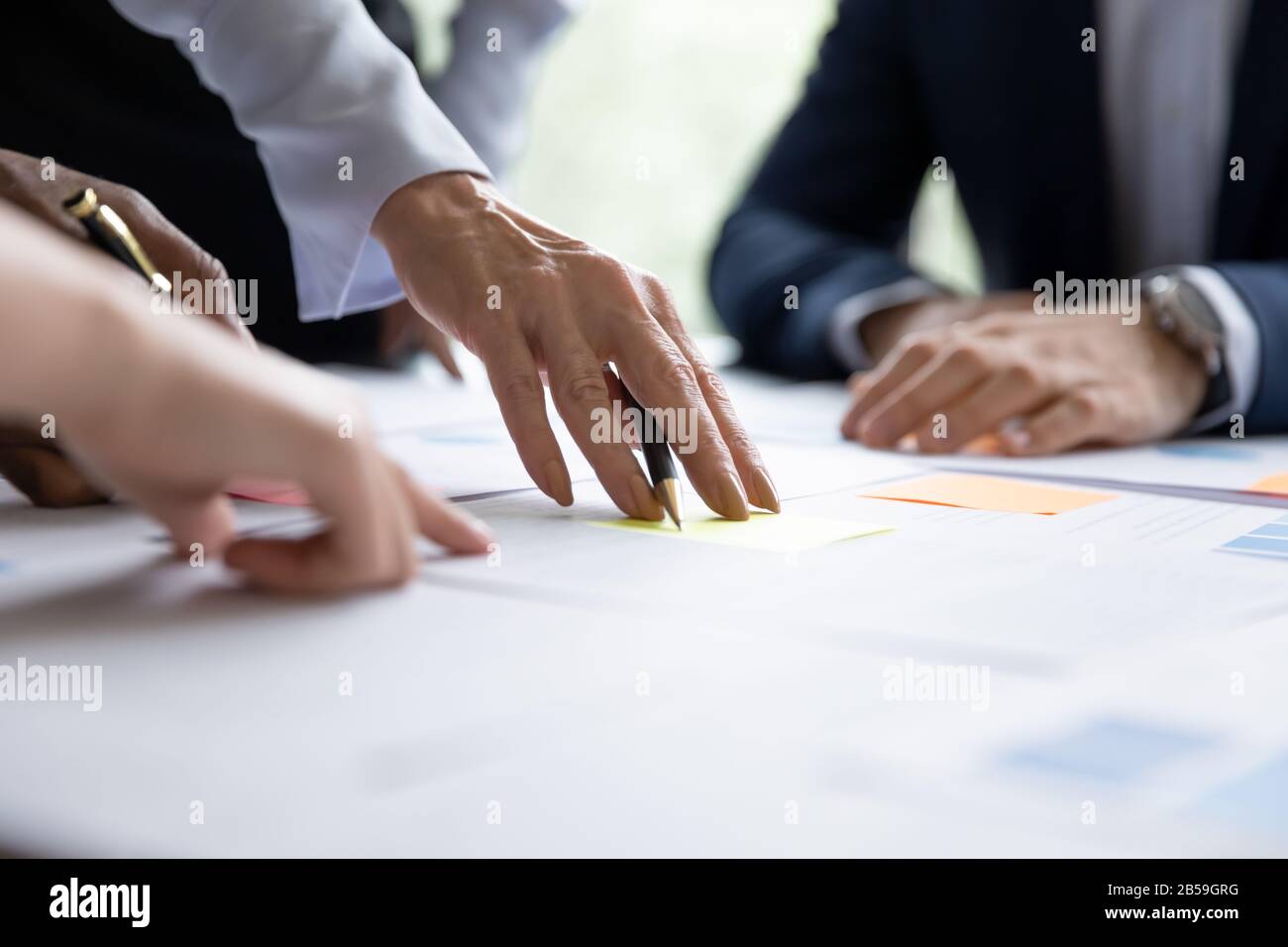 Close up of diverse businesspeople collaborating at meeting Stock Photo