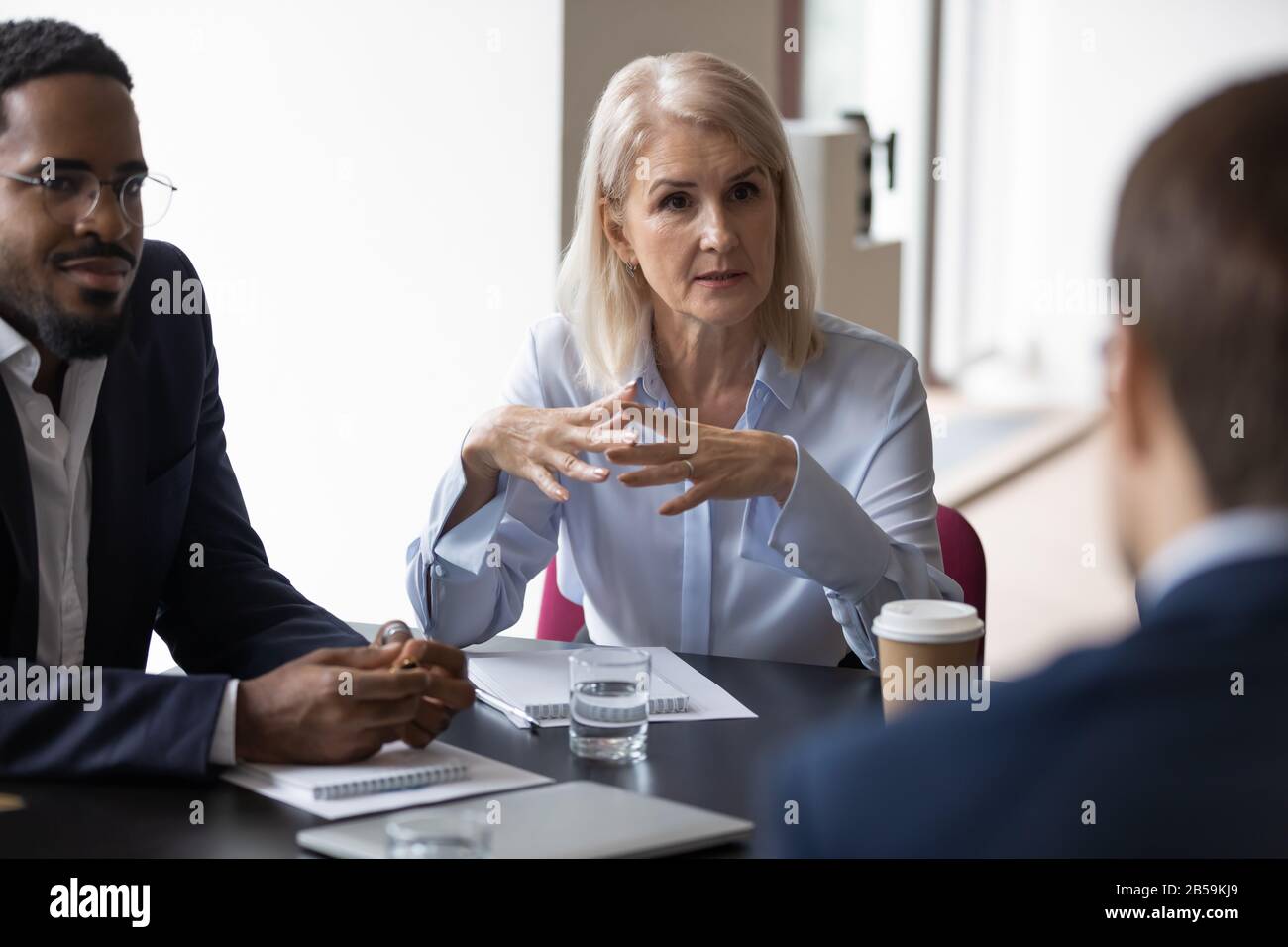 Diverse businesspeople discuss project at meeting together Stock Photo