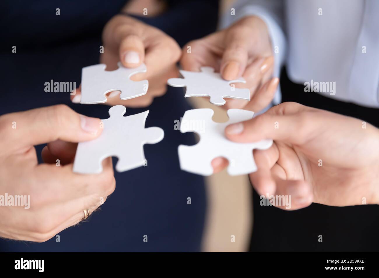 Close up of businesspeople assemble jigsaw puzzle at work Stock Photo