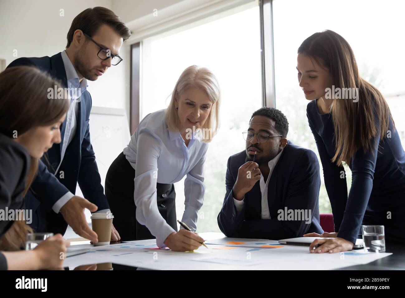 Multiracial businesspeople cooperate at office briefing together Stock Photo