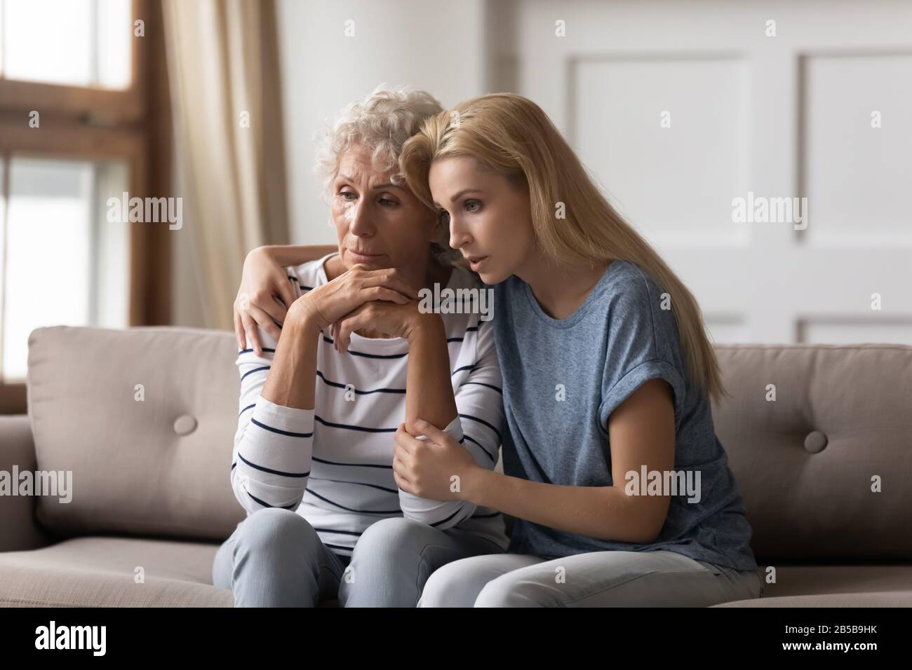 Supportive adult daughter comfort distressed mature mom Stock Photo