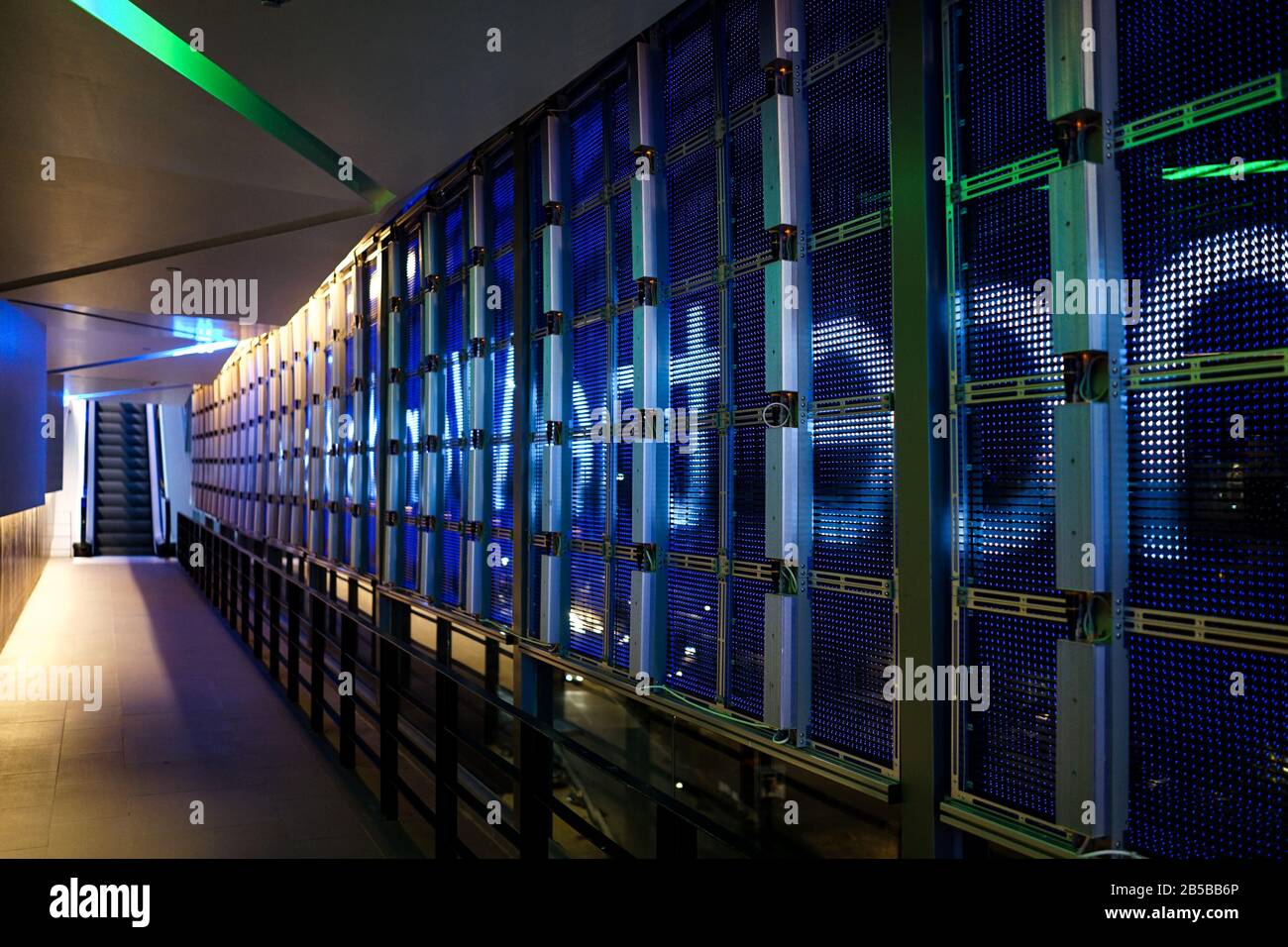 LED pattern system on the mirror glass wall from inside the building to outside with escalator. Stock Photo