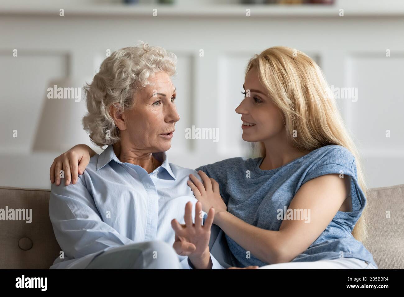 Mature mom and adult daughter relax talking at home Stock Photo