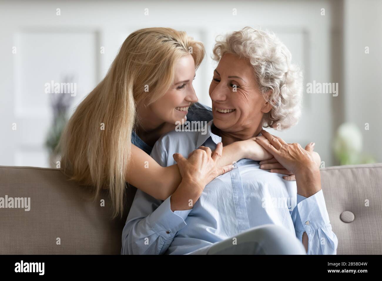 Smiling adult daughter hug mature mom showing love Stock Photo
