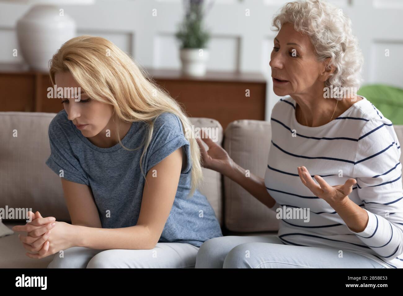 Pushy mature mother talk lecture distressed adult daughter Stock Photo