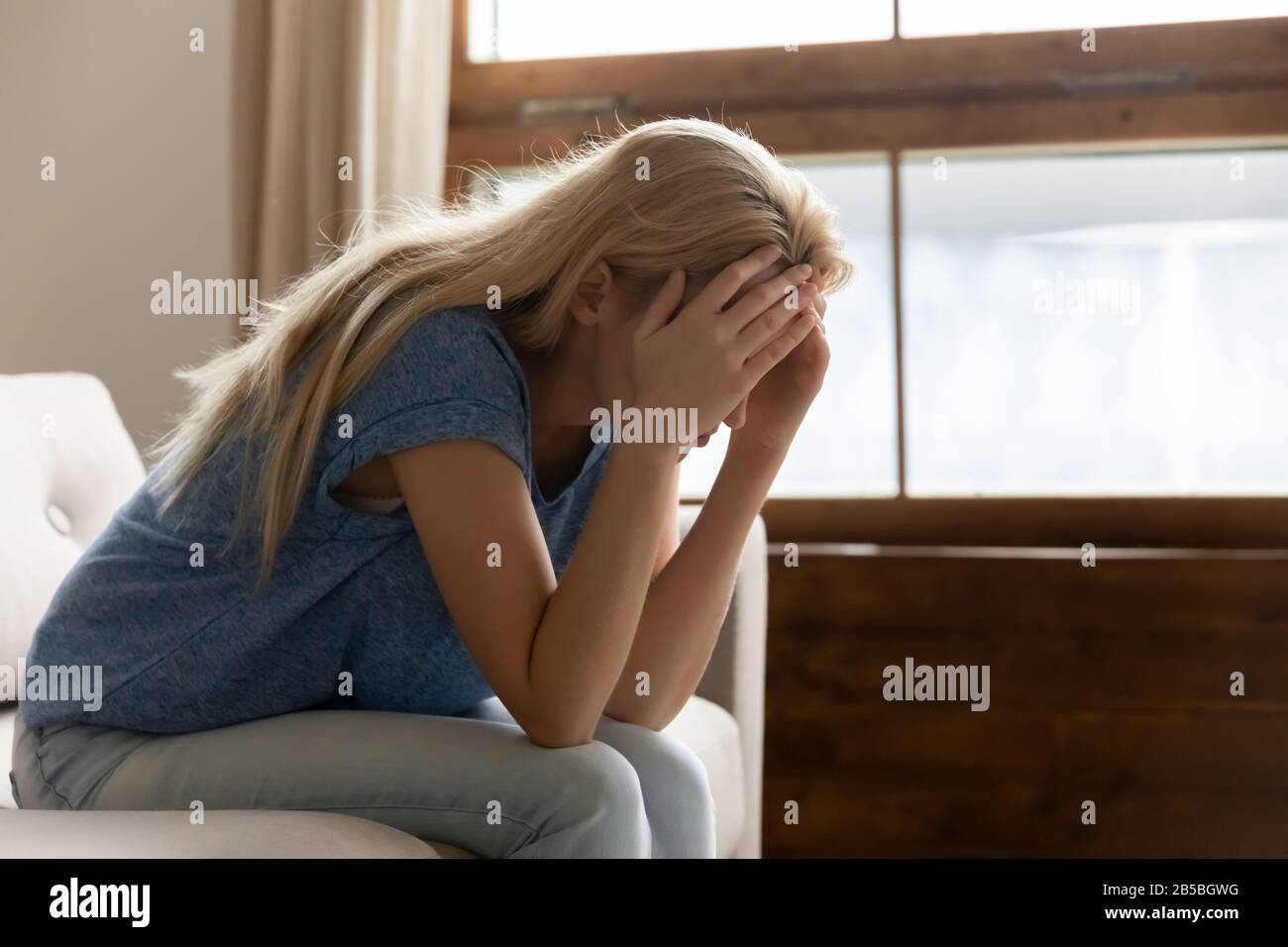 Unhappy young woman lost in thoughts having problems Stock Photo