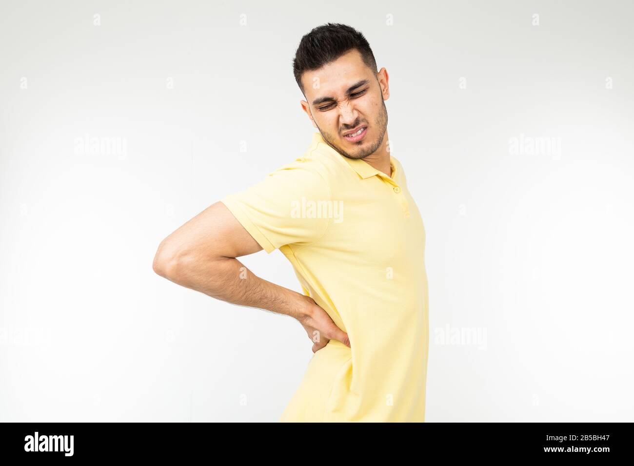man pulled back muscle on a white studio background Stock