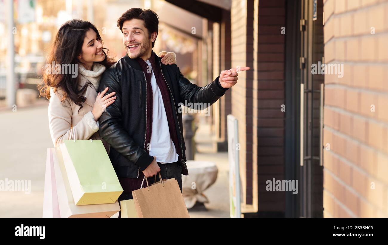Guy Offering Guy offering his girlfriend to come in the shopping mall Stock Photo ...