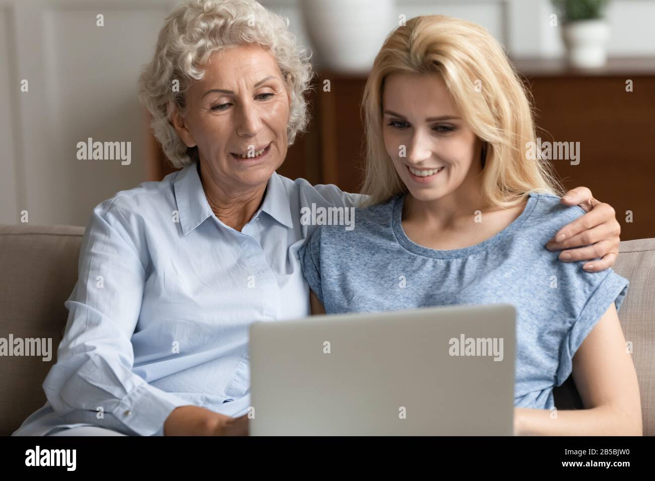 Happy senior mother and adult daughter using laptop Stock Photo