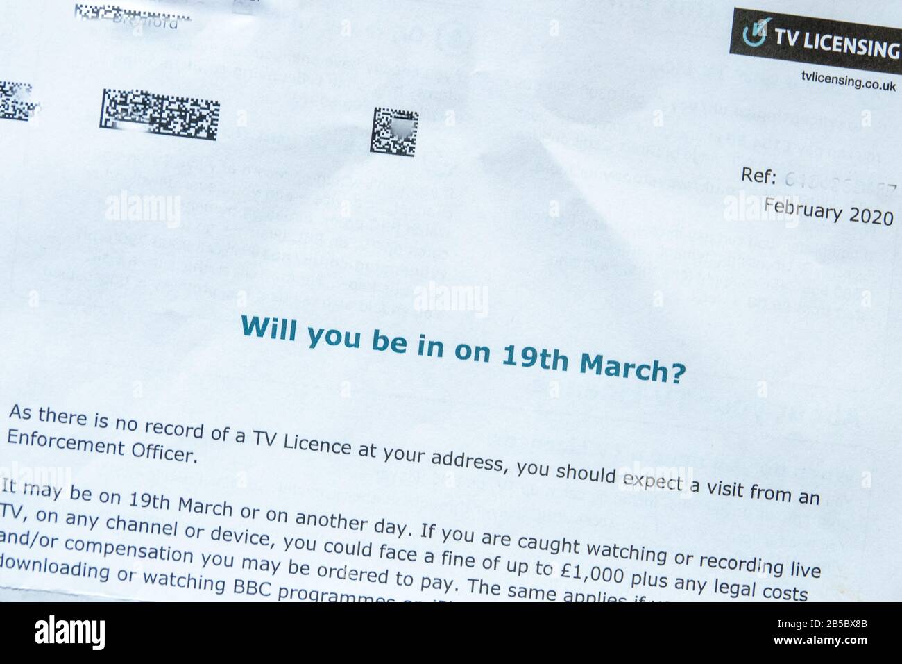 UK TV licence reminder or threatening letter sent to the legal occupier of a house to warn of the imminent visit to the property from enforcement officers. Stock Photo