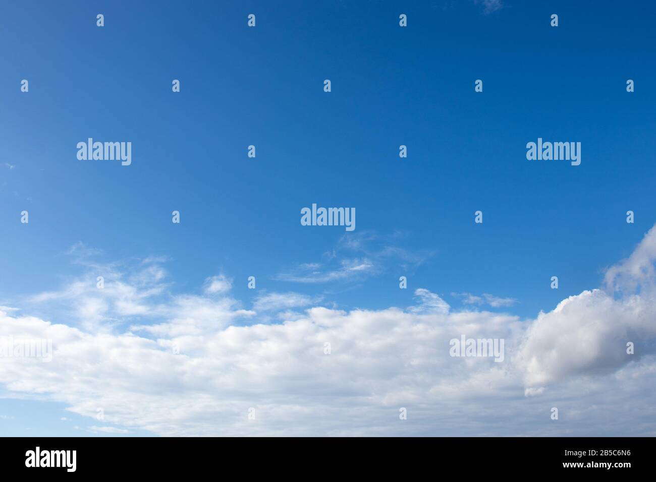 White fluffy clouds on bright blue sky Stock Photo