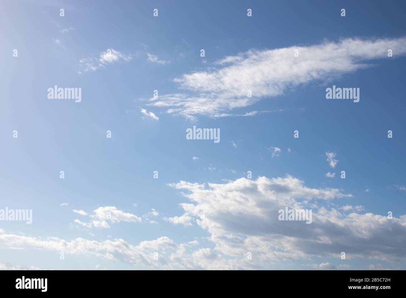 White fluffy clouds on bright blue sky Stock Photo