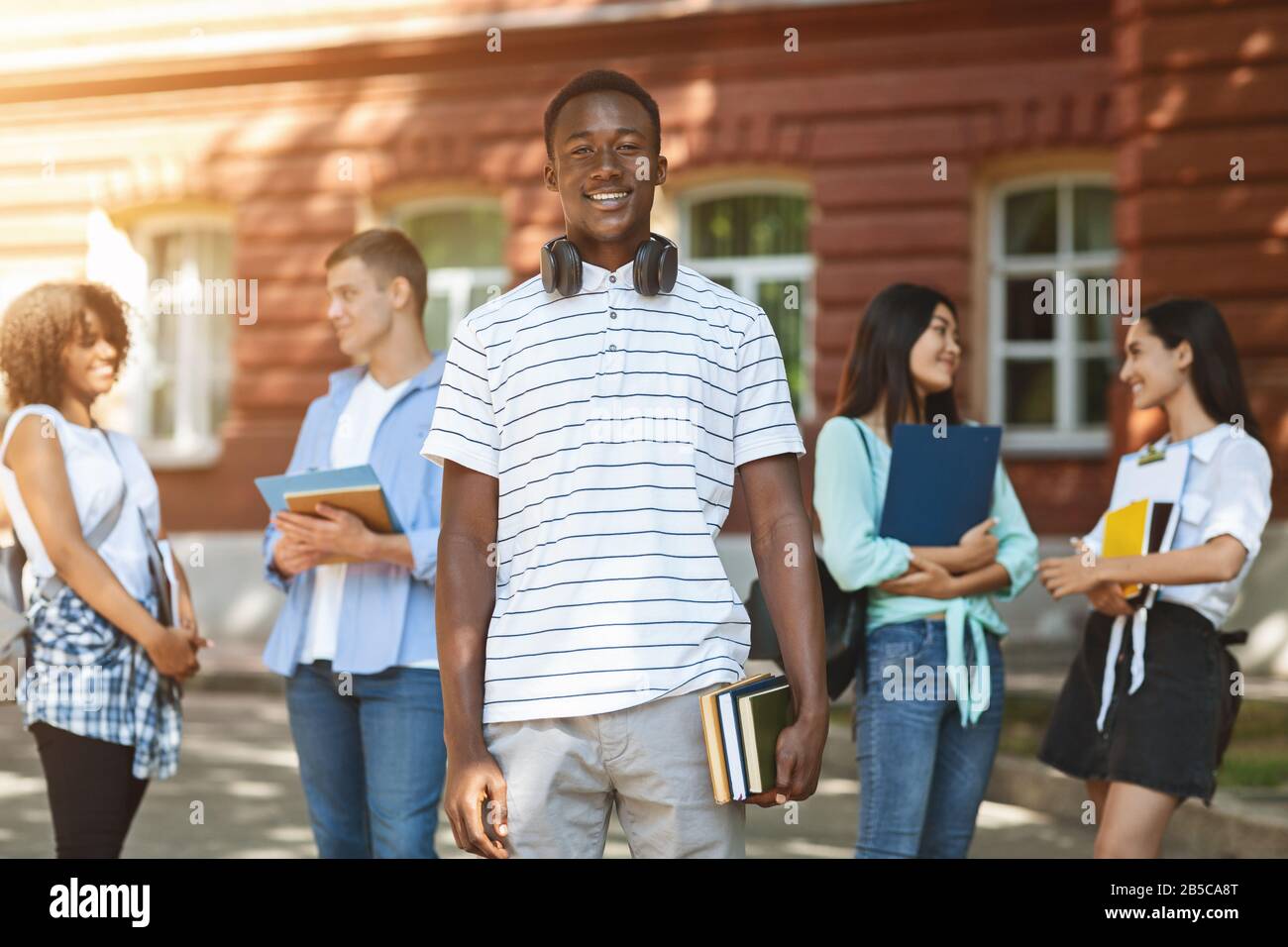 Education grants. Portrait of happy african student posing in university campus Stock Photo
