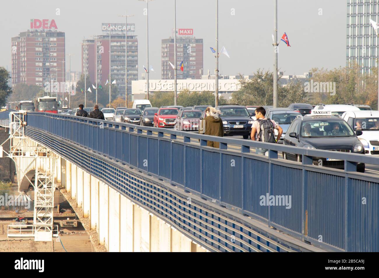Belgrade, Serbia - October 17, 2019 : Pedestrians and vehicles crossing the city street Branko bridge,, on a sunny polluted day Stock Photo
